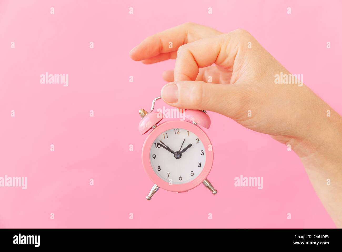 Simply design female woman hand holding ringing twin bell alarm clock