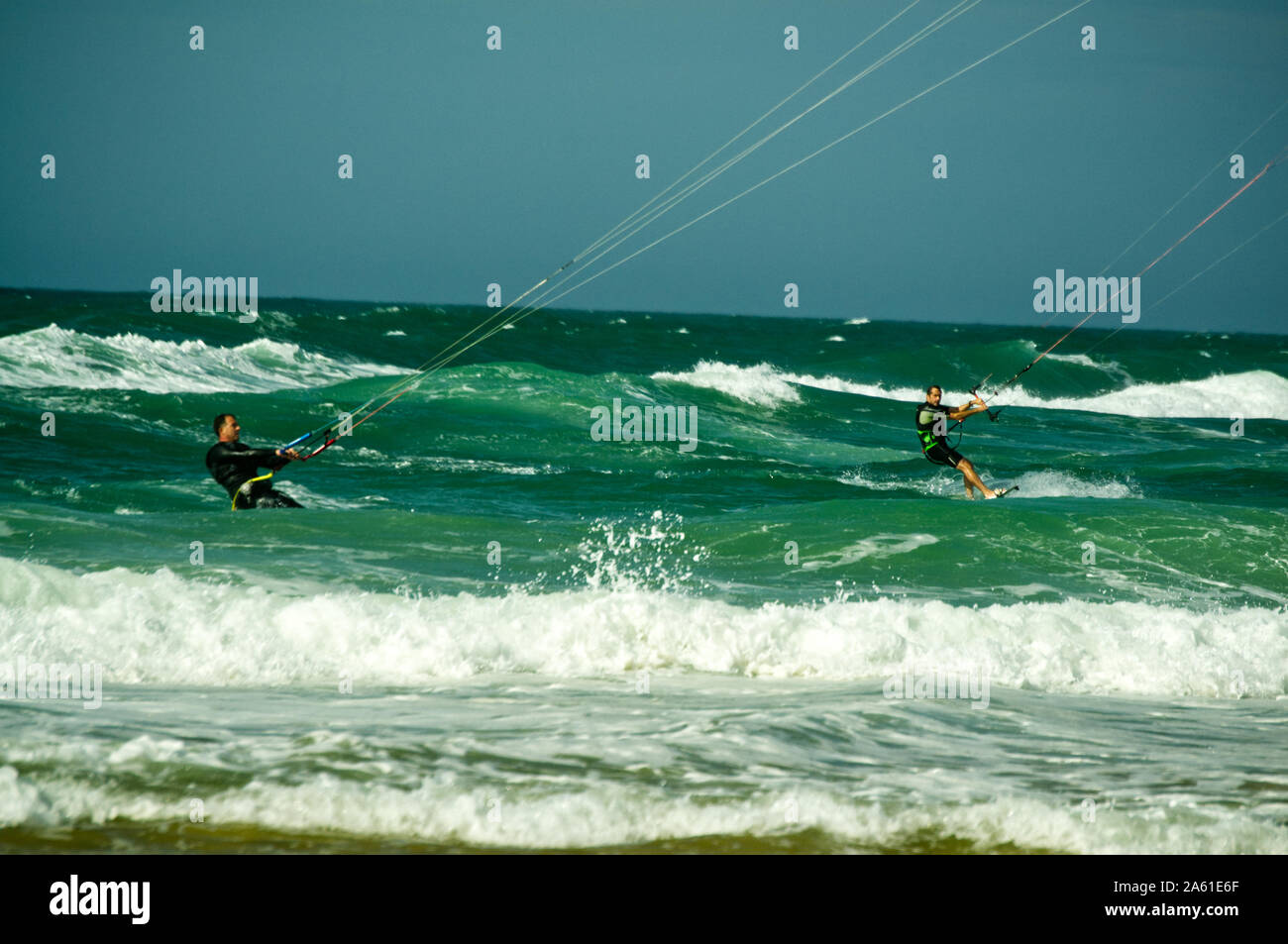 Pair of kite surfers in rough seas and breaking waves of the Atlantic coast at Lacanau-Océan, France. Stock Photo