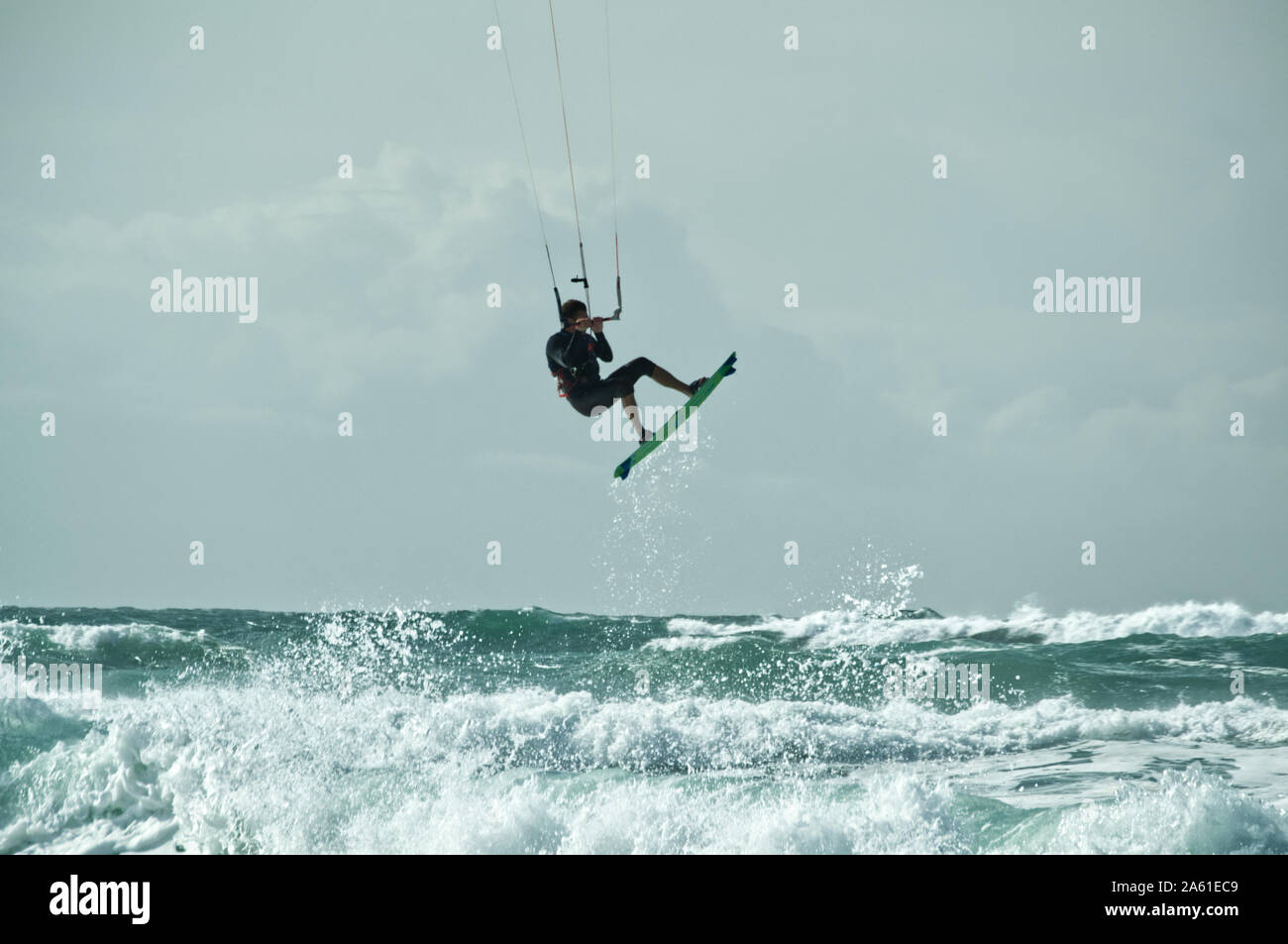 Kite surfer jumping off a breaking wave and flying through the air, lifted by the kite, Atlantic coast, Lacanau-Océan, France. Stock Photo