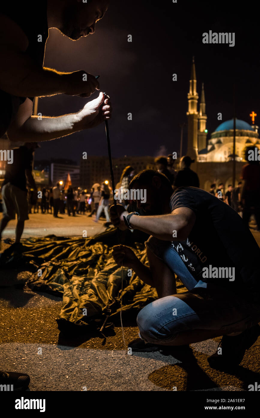 Protestors pitch a tent as they settle in for the long haul in Martyrs Square, Beirut. They say will not leave until the entire government has stepped down. Across the country similar mass gatherings are occurring as the people come together for a 7th consecutive day. United under one flag, this multi-sect country is calling for an end to its sectarian government and retribution for the corruption it has been subject to for 30 years. Stock Photo