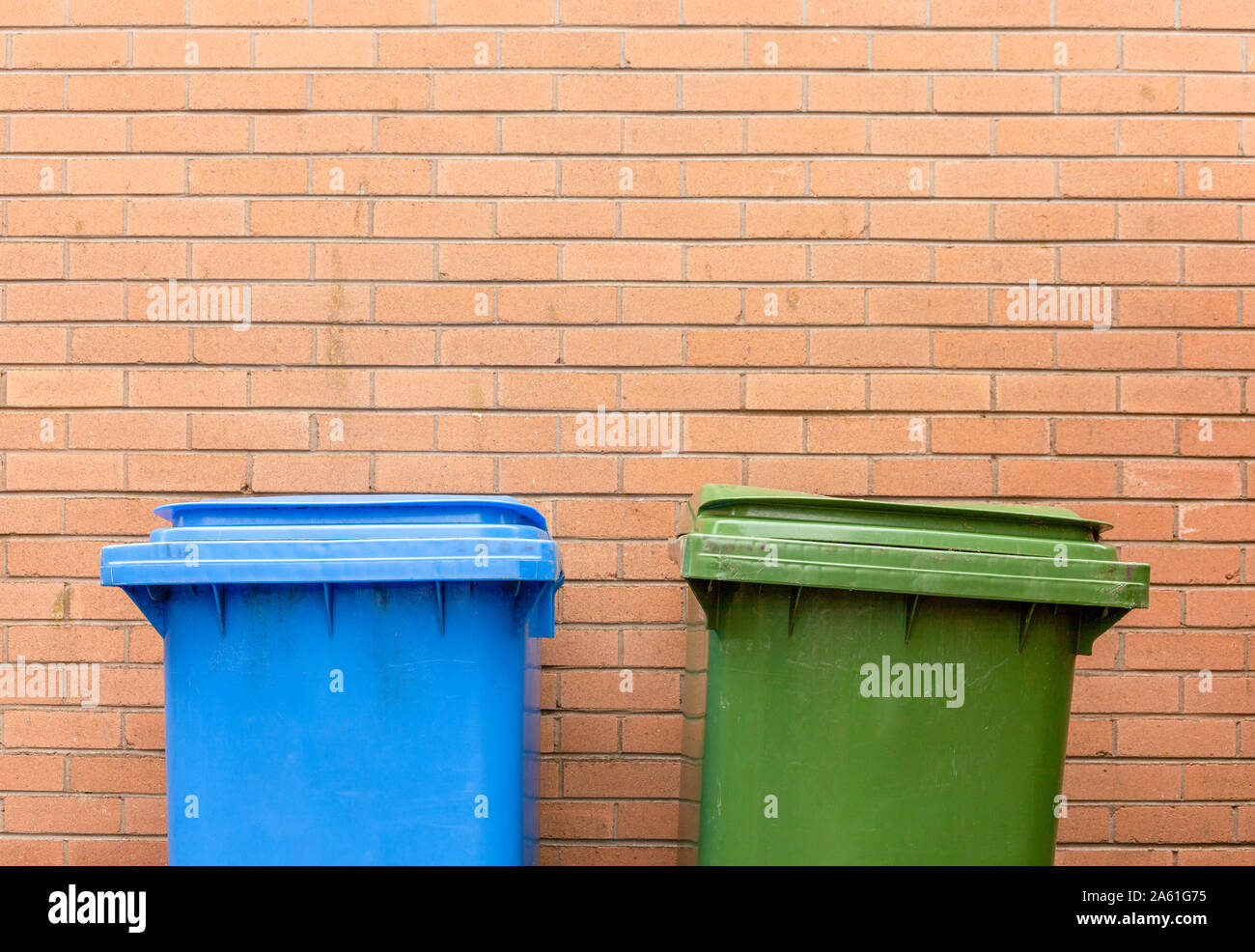 Recycling bins against brick wall hires stock photography and images