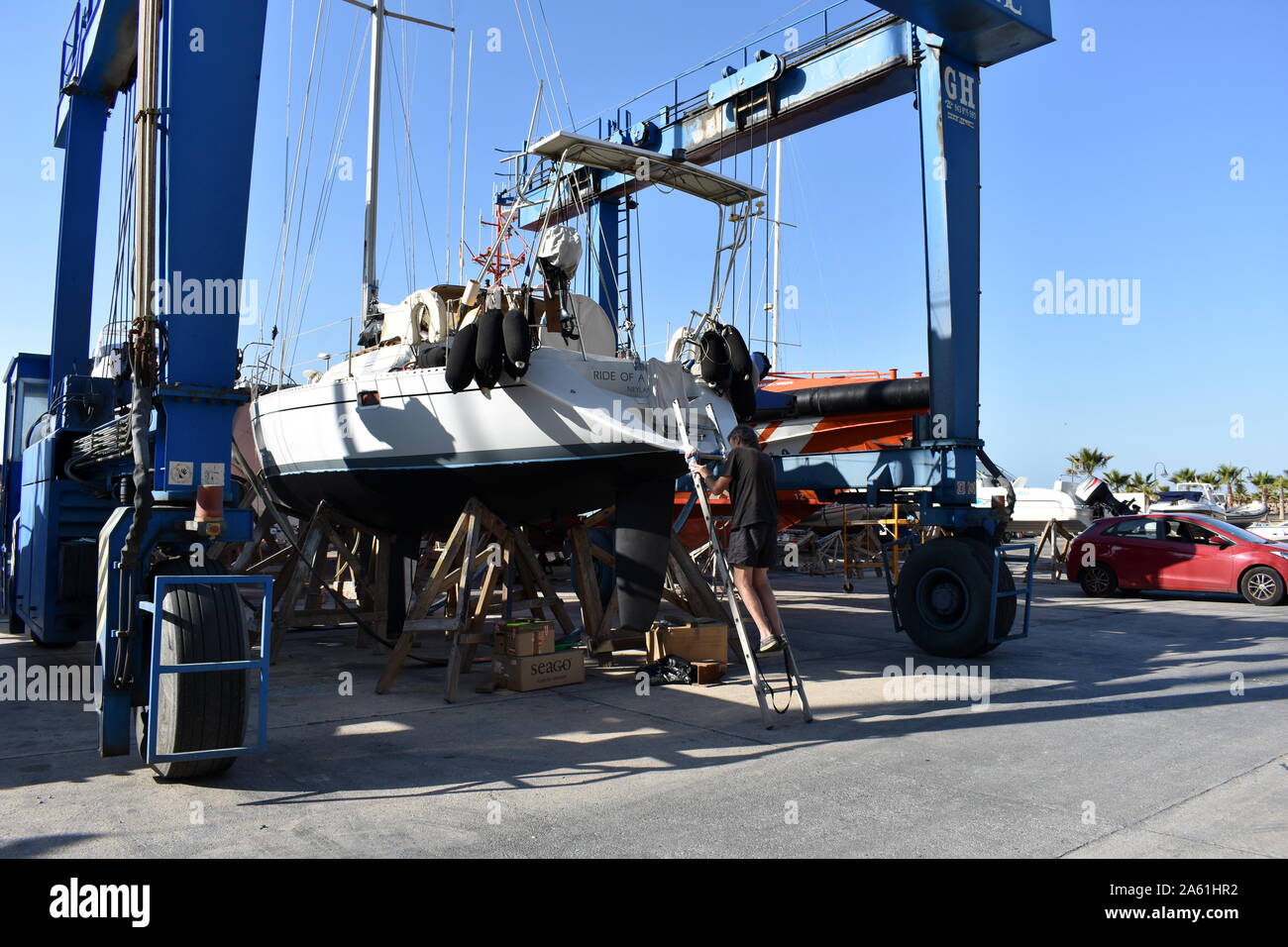 Sailing boat about to be moved by travel lift in Aguadulce marina boat yard, Aguadulce, Almeria, Spain Stock Photo