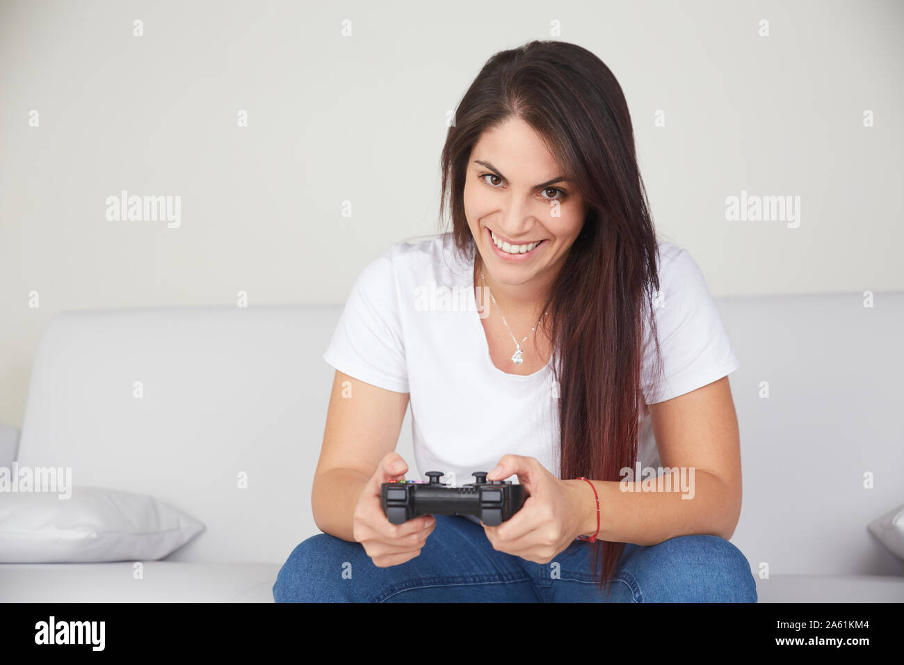 pretty woman play videogames on sofa Stock Photo - Alamy