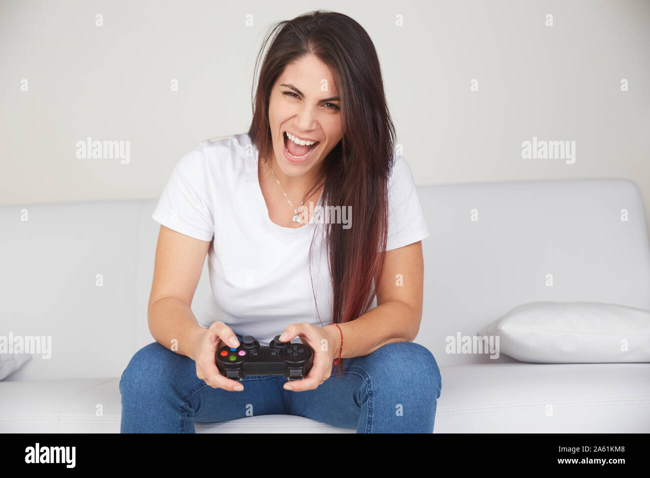 pretty woman play videogames on sofa Stock Photo - Alamy