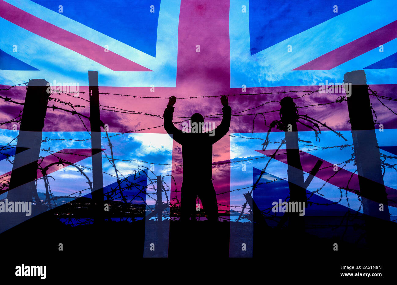 Man looking through barbed wire, razor wire fence at night. Brexit, illegal immigration, human trafficking,  asylum... concept image Stock Photo