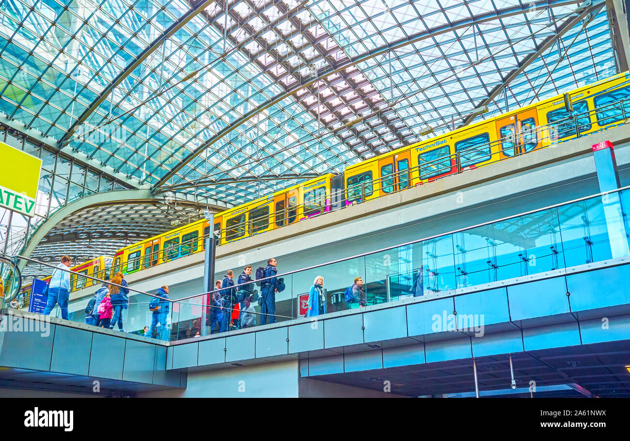 BERLIN, GERMANY - OCTOBER 3, 2019: The large hall of Hauptbahnhof (Central Railway Station), with yellow train of U-bahn line standing on the upper ti Stock Photo