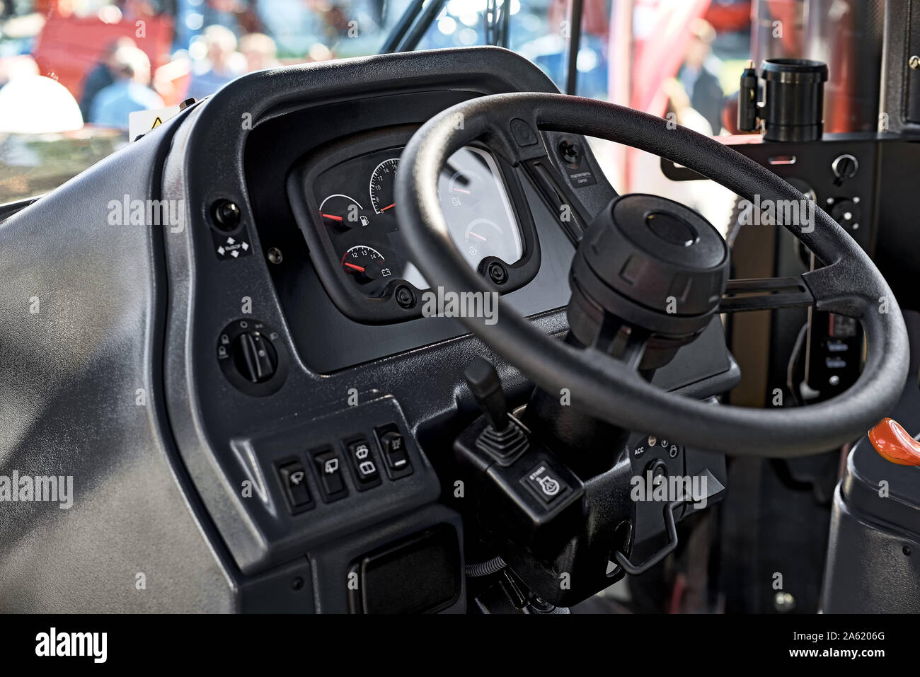 Steering wheel and the controls in the cabin of the new tractor, view inside Industrial Vehicle. Stock Photo