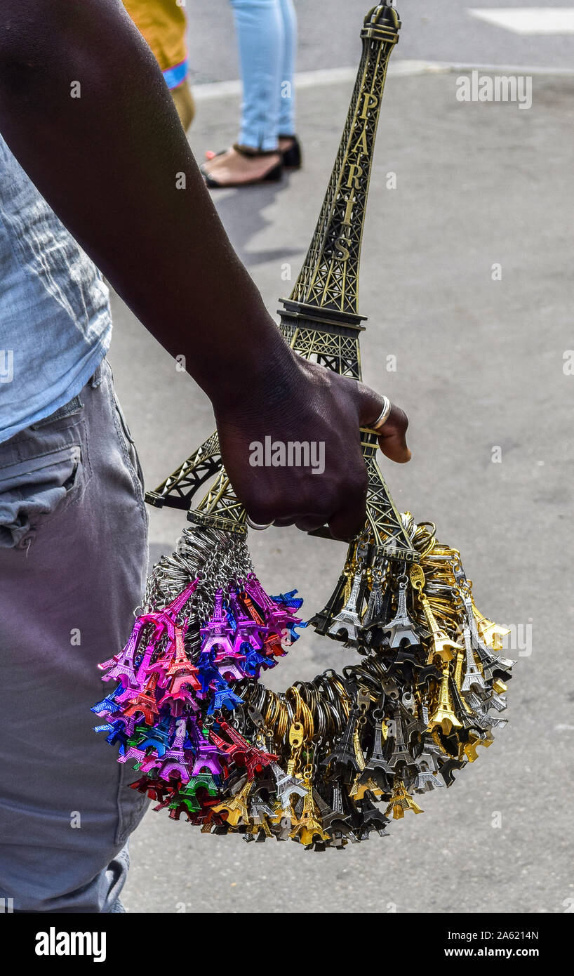 A black hand holding a bunch of different coloured Eiffel tower keyrings in Paris, France Stock Photo