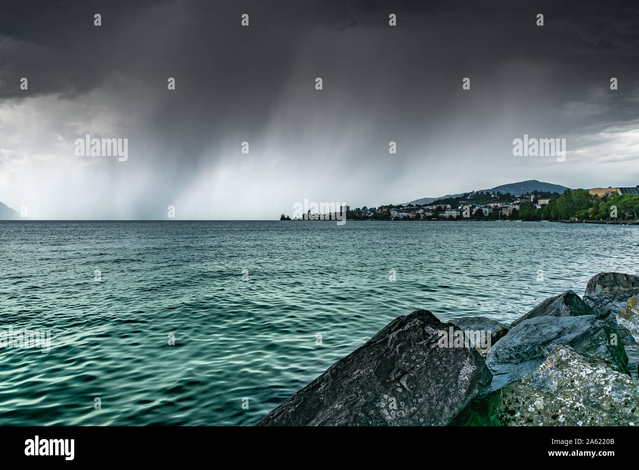 View of the city of Clarens on the shores of Lake Geneva and dark rainy clouds.Montreux,Switzerland. Stock Photo