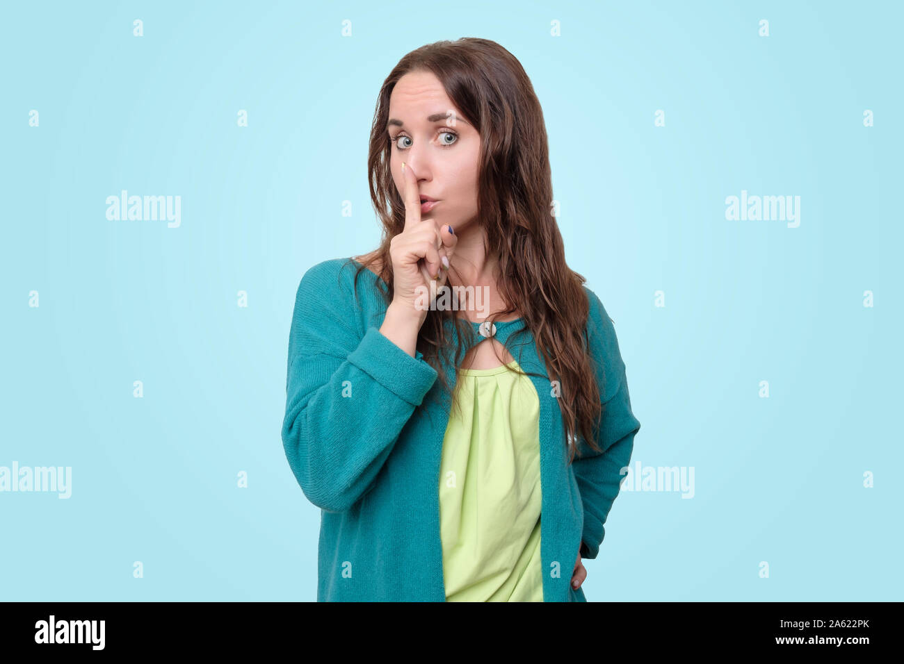 Young woman making gesture of silence. It is top secret news. Stock Photo