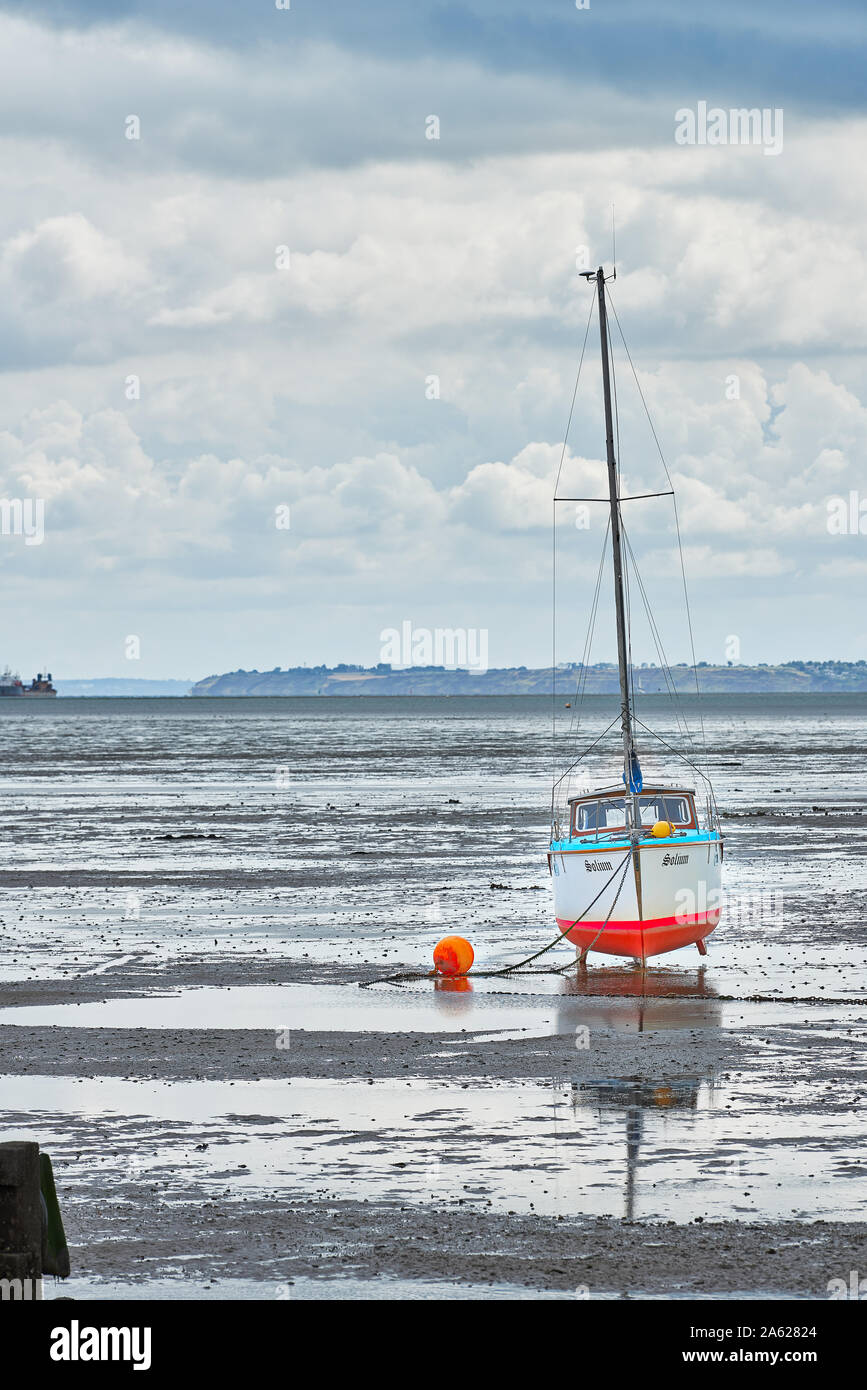 Yacht moored on the mud flats of the river Thames estuary at Thorpe Bay