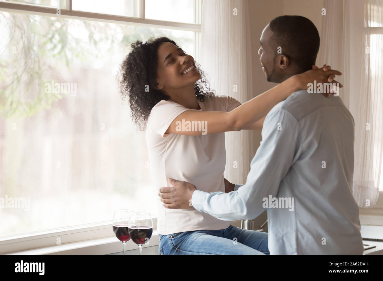 Laughing just married family couple enjoying weekend time at kitchen. Stock Photo