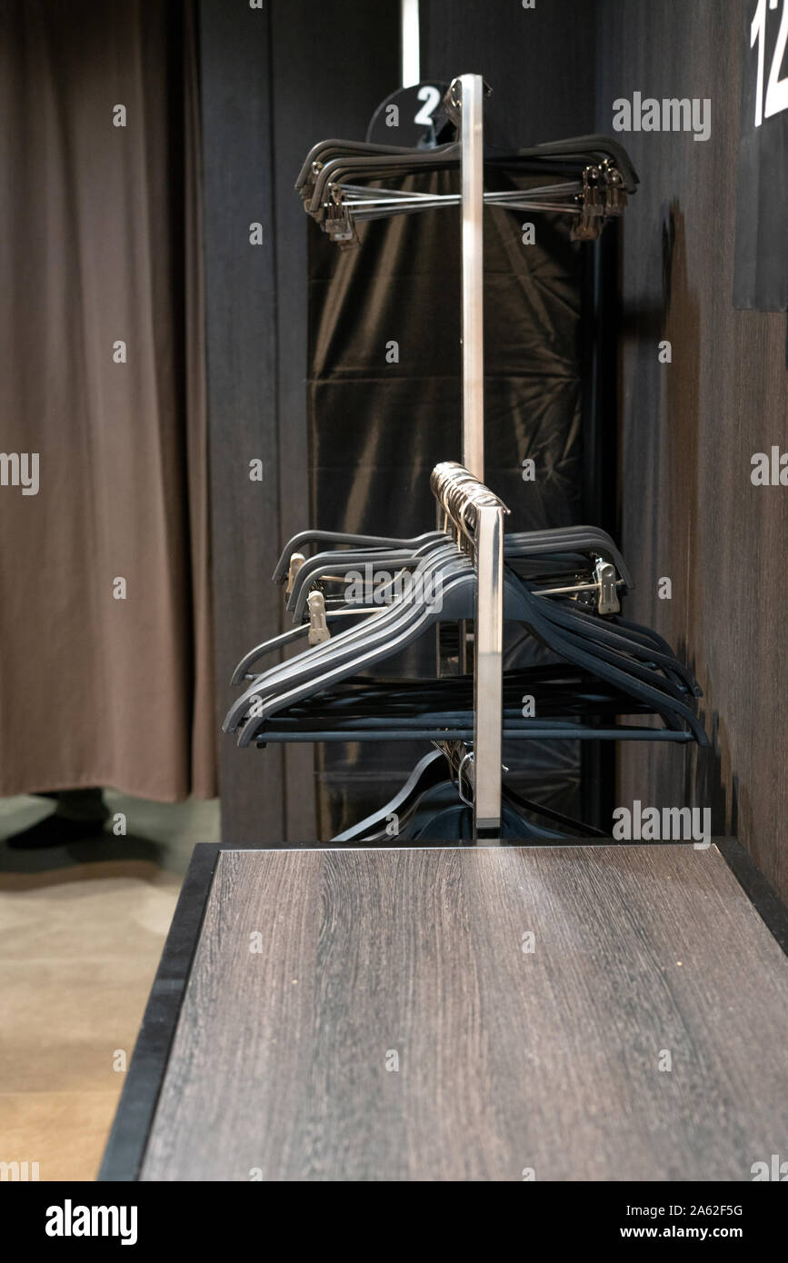 Floormounted white coat hanger with empty coat hanger. Wardrobe