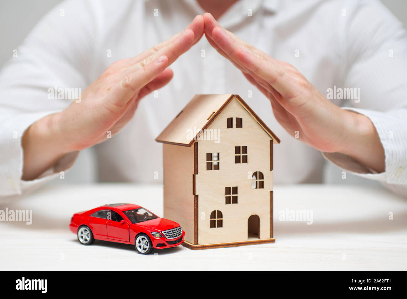 Insurance concept of car insurance, home insurance to protection by hands. House and car insurance concept. Stock Photo