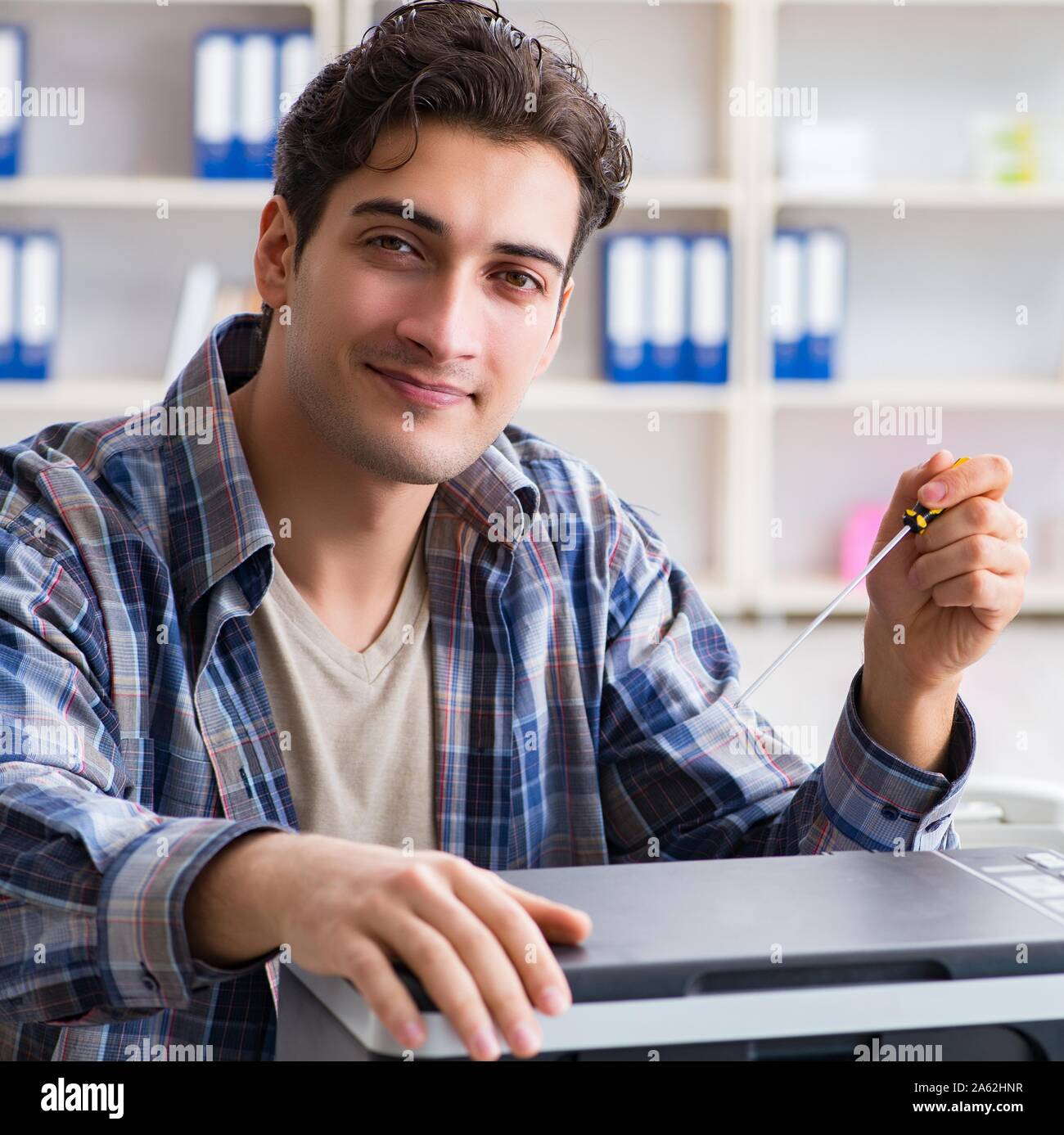 The hardware repairman repairing broken printer fax machine Stock Photo