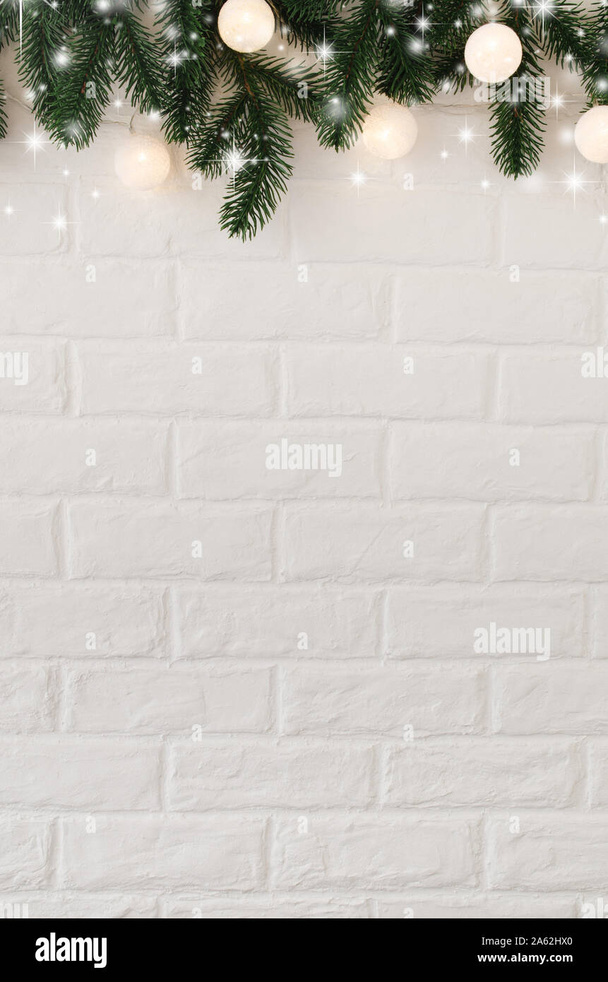 Christmas of New Year background. White brick wall with fir branches