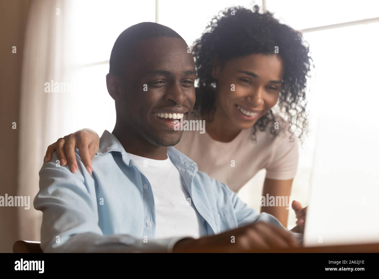 Close up head shot young mixed race family couple watching comedian