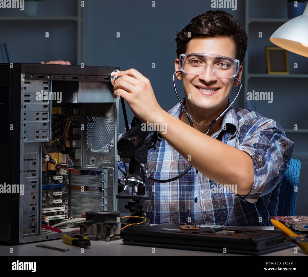 Computer repair concept with man inspecting with stethoscope Stock
