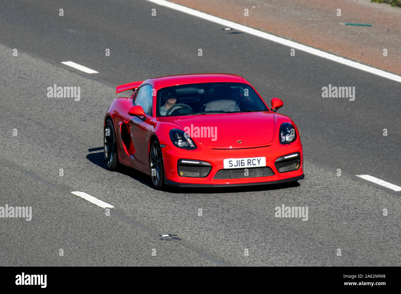 2016 red Porsche Cayman GT4; UK Vehicular traffic, transport, modern, saloon cars, south-bound on the 3 lane M6 motorway highway. UK Stock Photo