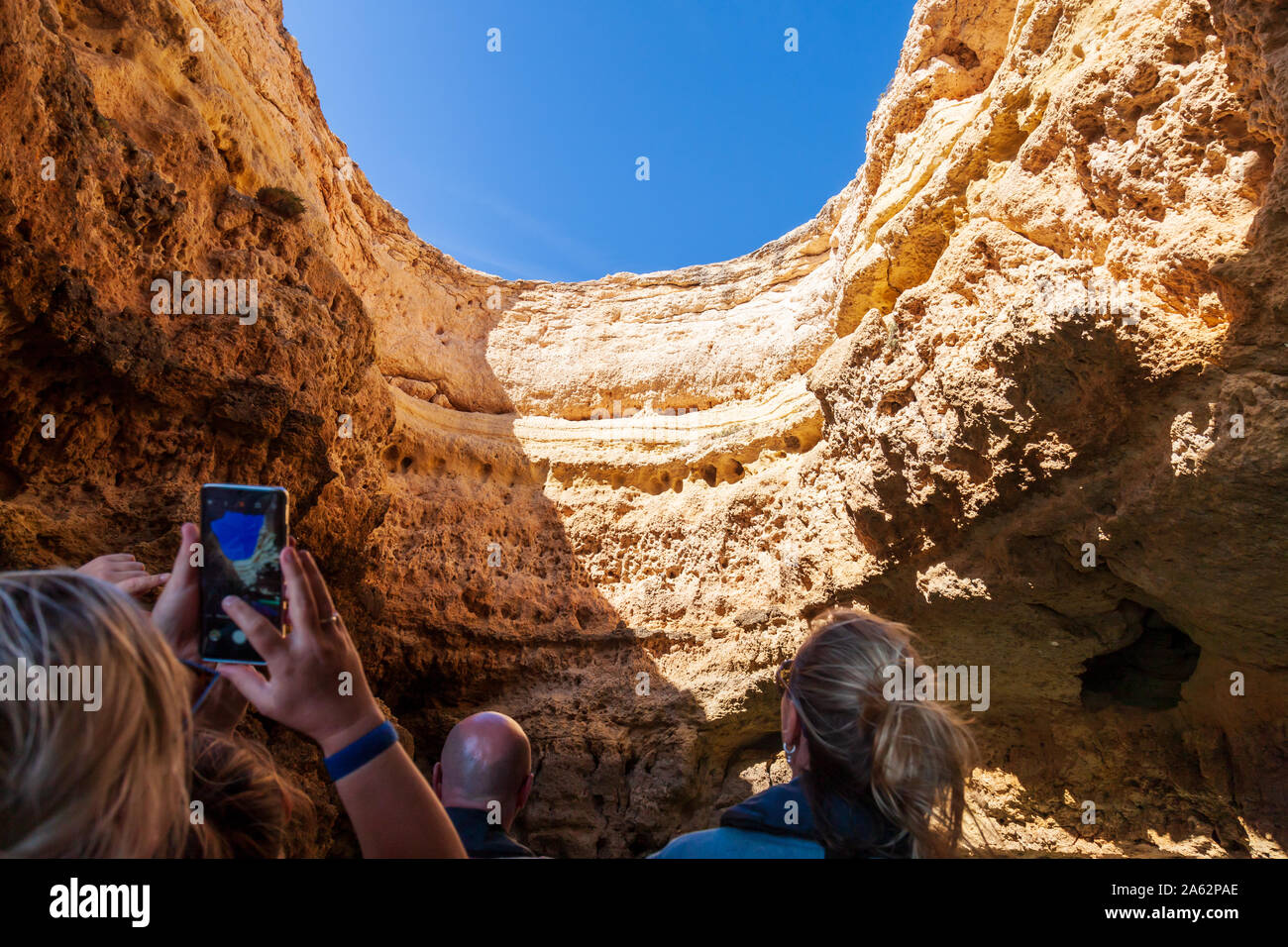 tourists enjoying boat tour of sea caves on algarve coast portugal Stock Photo