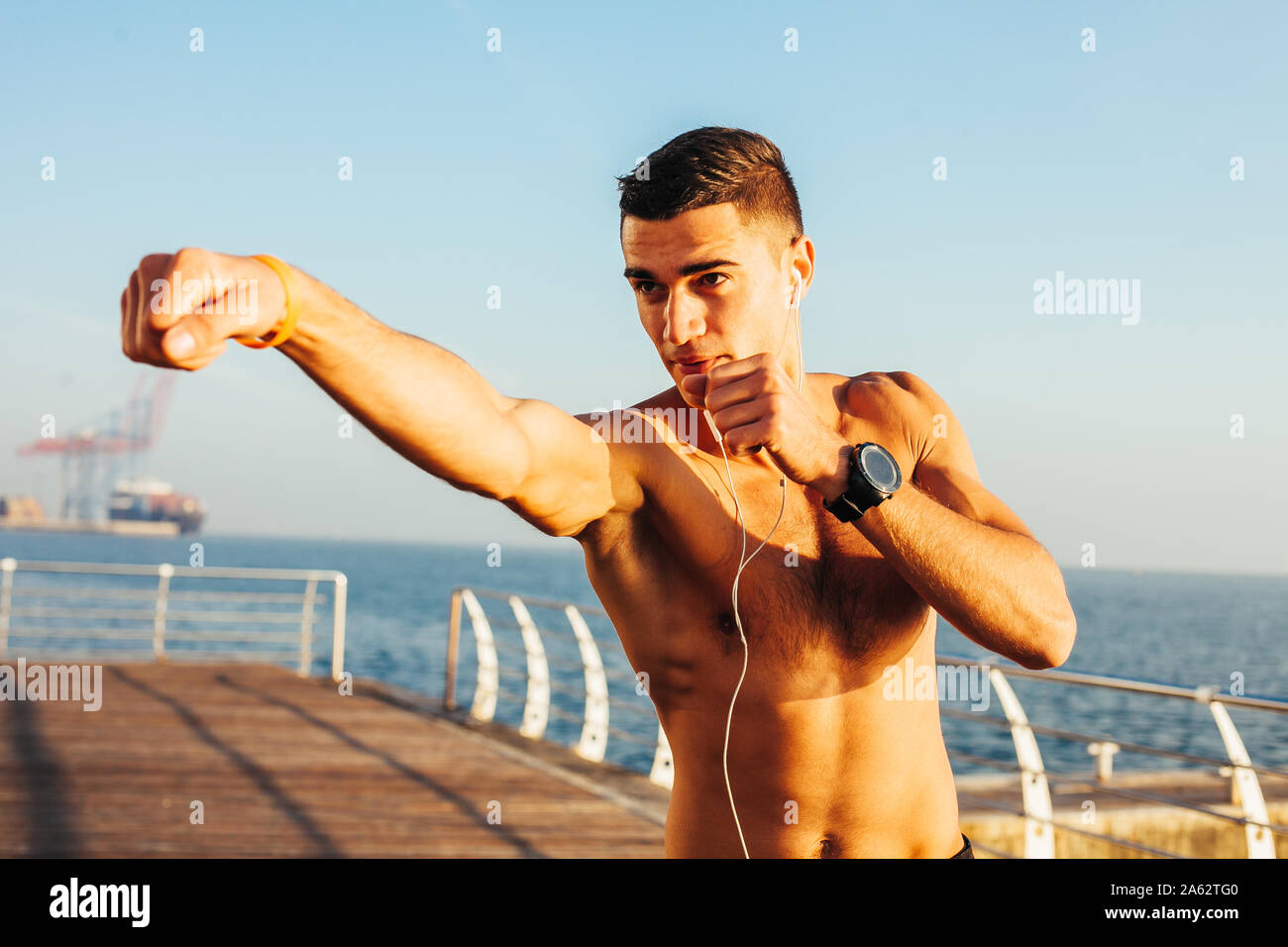 Sporty guy boxing on training by the sea Stock Photo
