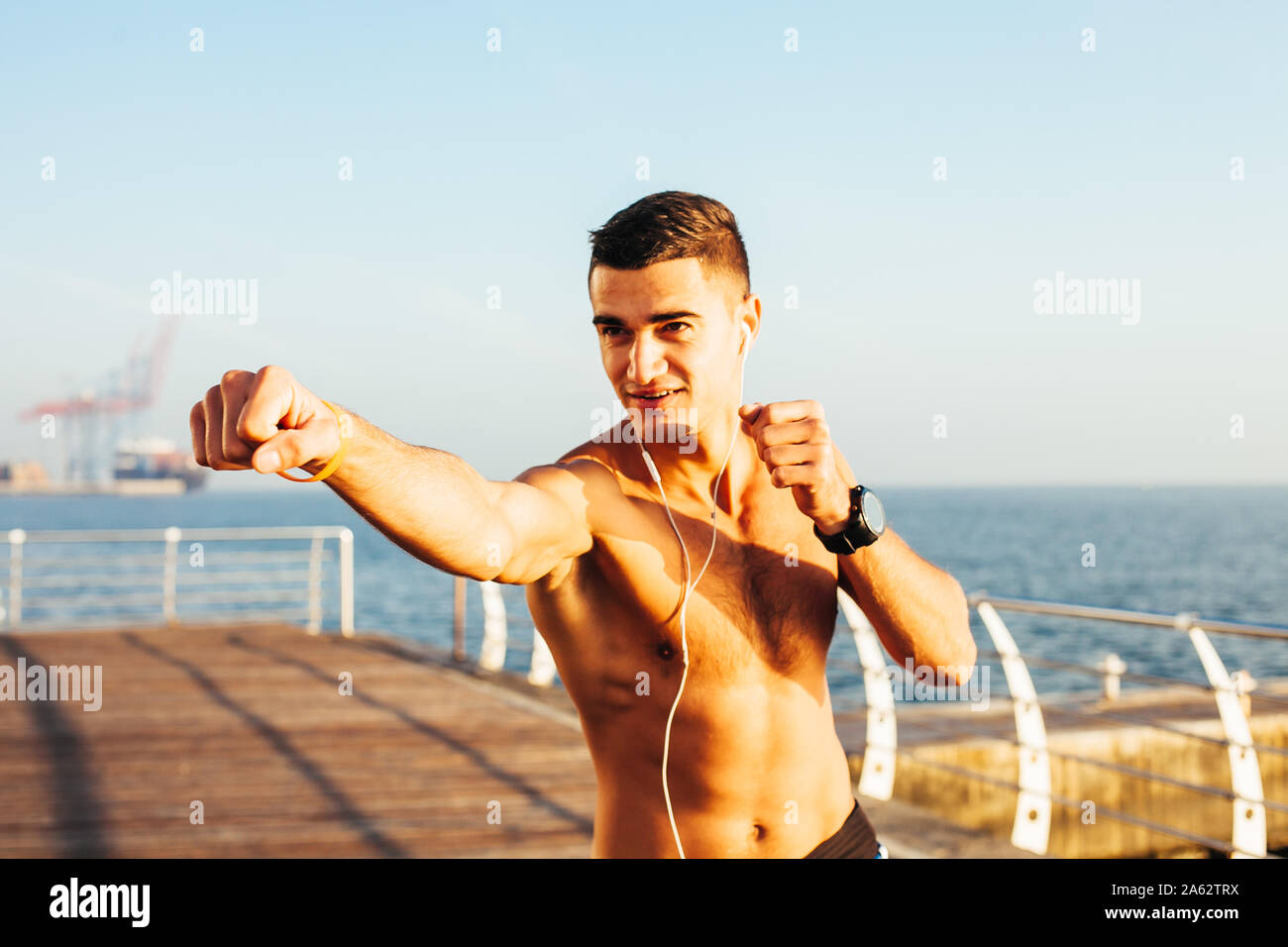 Sporty guy boxing on training by the sea Stock Photo