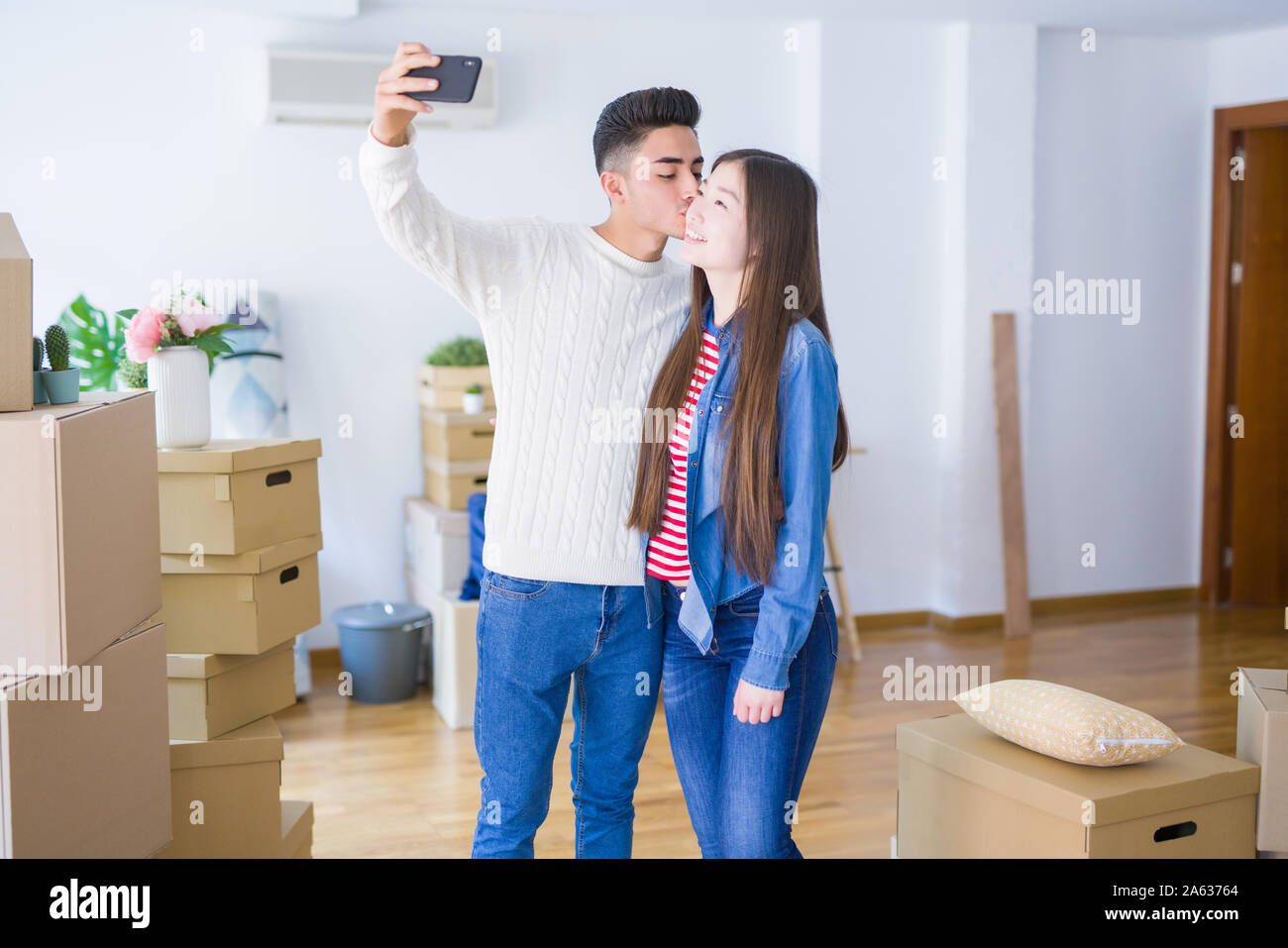 Young asian couple smiling taking a selfie photo with smartphone ...
