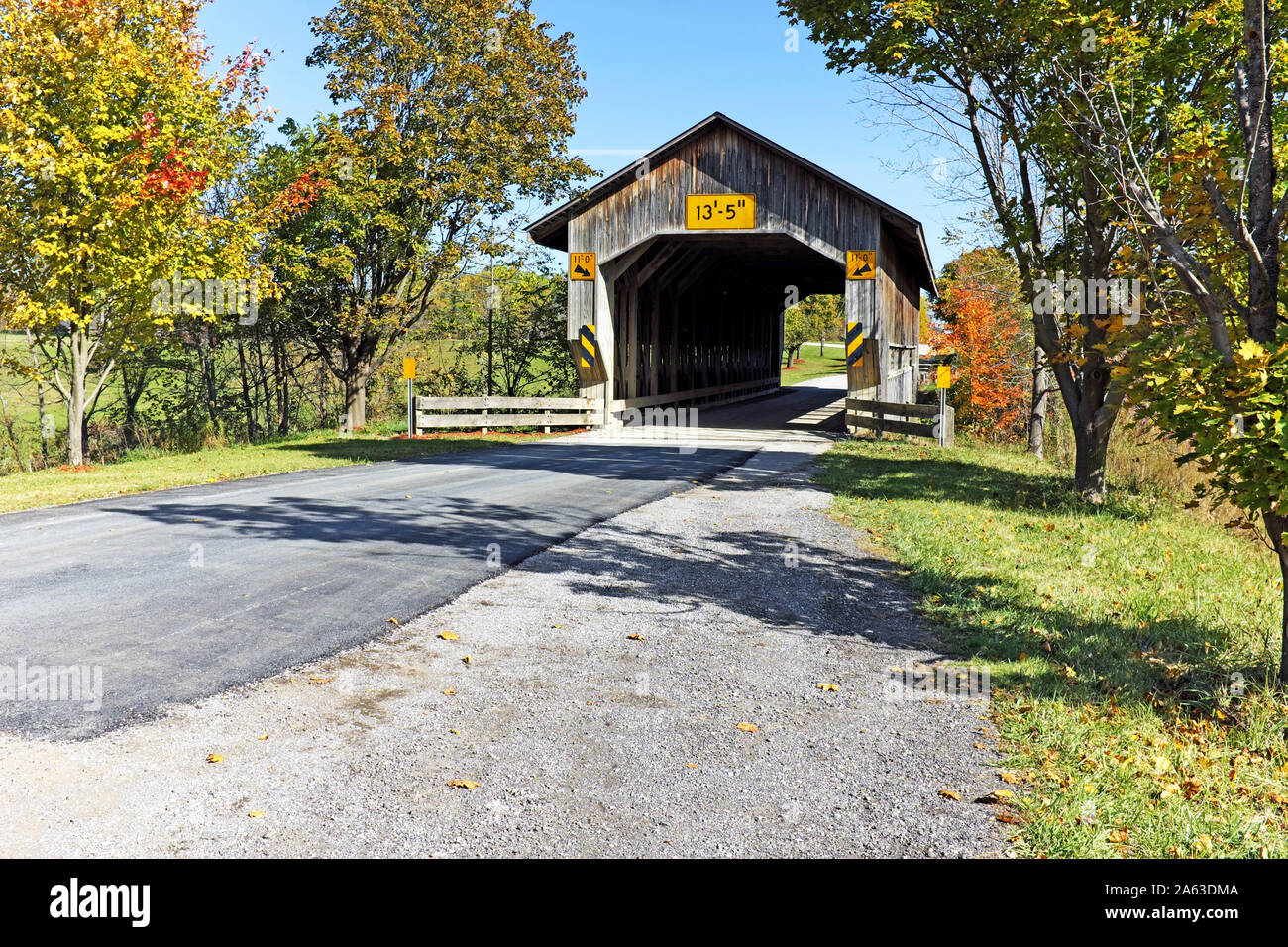 The Caine Road Bridge, one of many wooden covered bridges in Northeast Ohio, is the first Pratt Truss bridge in Ohio and located in Pierpont Township. Stock Photo