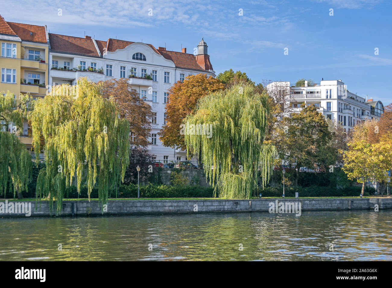 Berlin, Germany - October 14, 2019: Banks of the river Spree lined with weeping willow trees with typical for the district Westphalian quarter (german Stock Photo