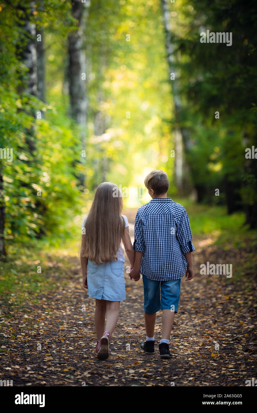 First Love Little Boy And Girl Holding Hands And Smiling While Walking Outdoors In Park Stock Photo Alamy