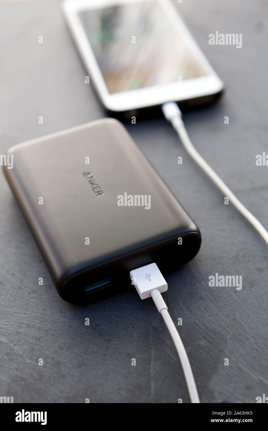 Anker power core15000 Redux portable power bank connected to and recharging  an iPhone 6 plus Stock Photo