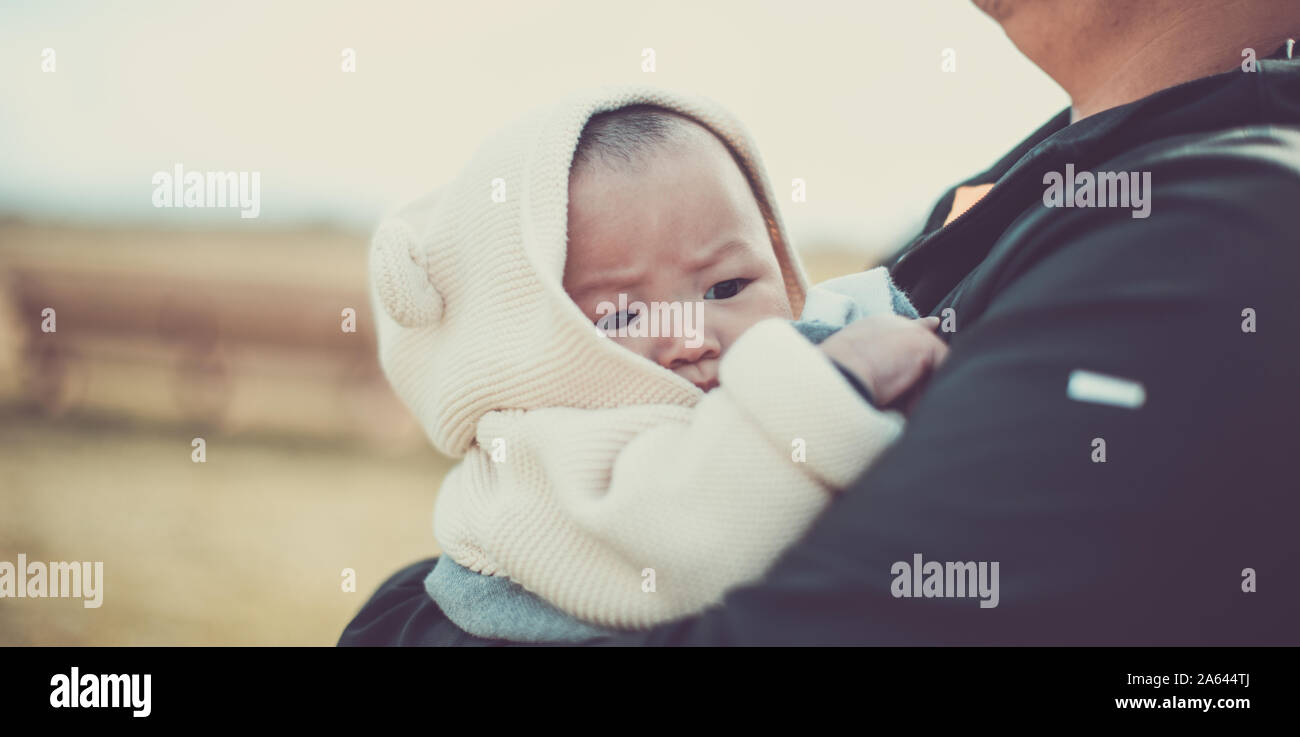 Asian baby in dads arms at the pumpkin patch, autumn background Stock Photo