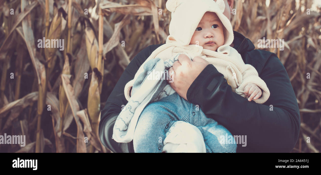 Asian baby in dads arms at the pumpkin patch, autumn background Stock Photo