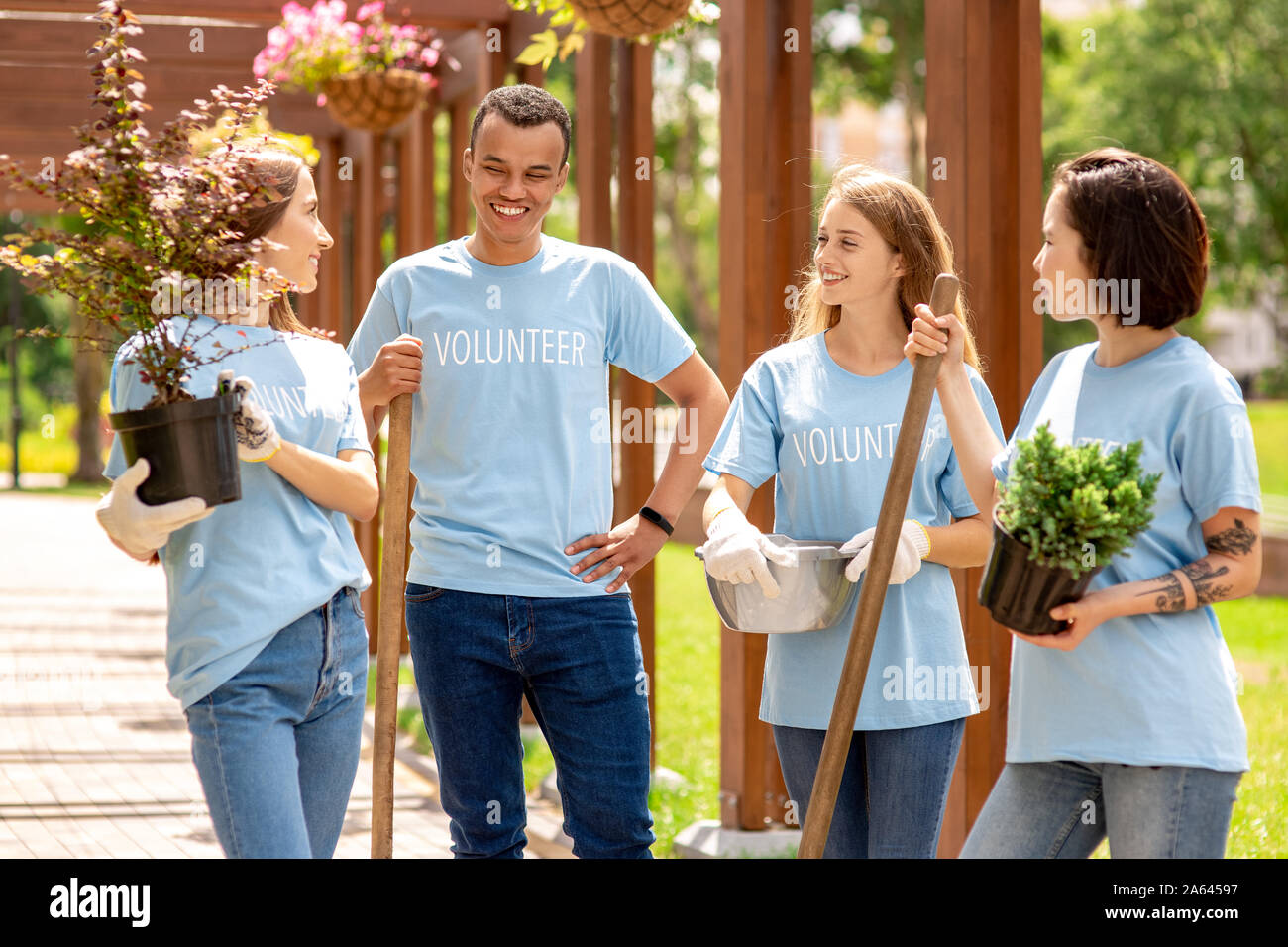 Volunteering. Young people volunteers outdoors standing with pots and