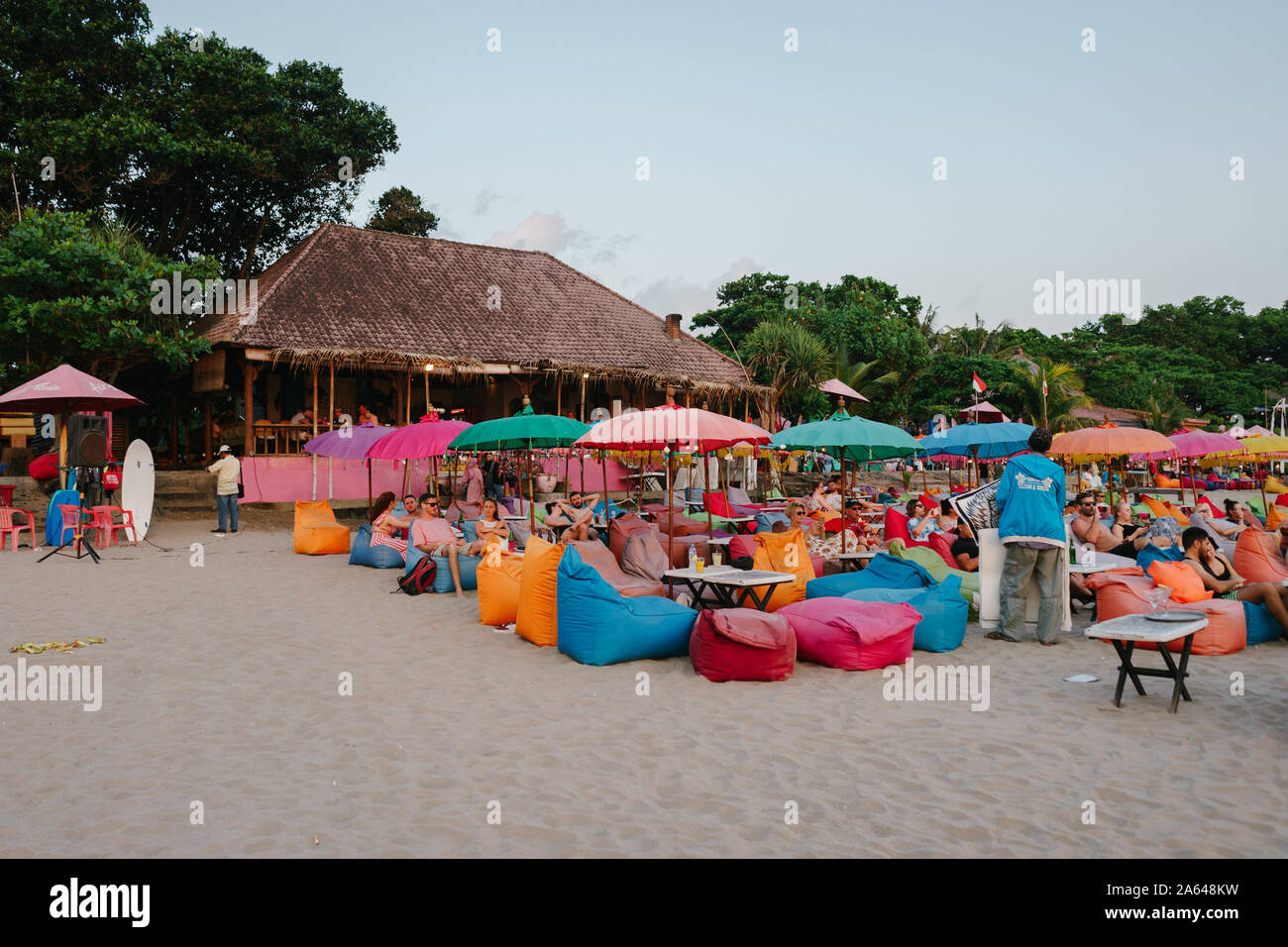 Tourists laying on colorful bean bags to see sunset from Seminyak beach