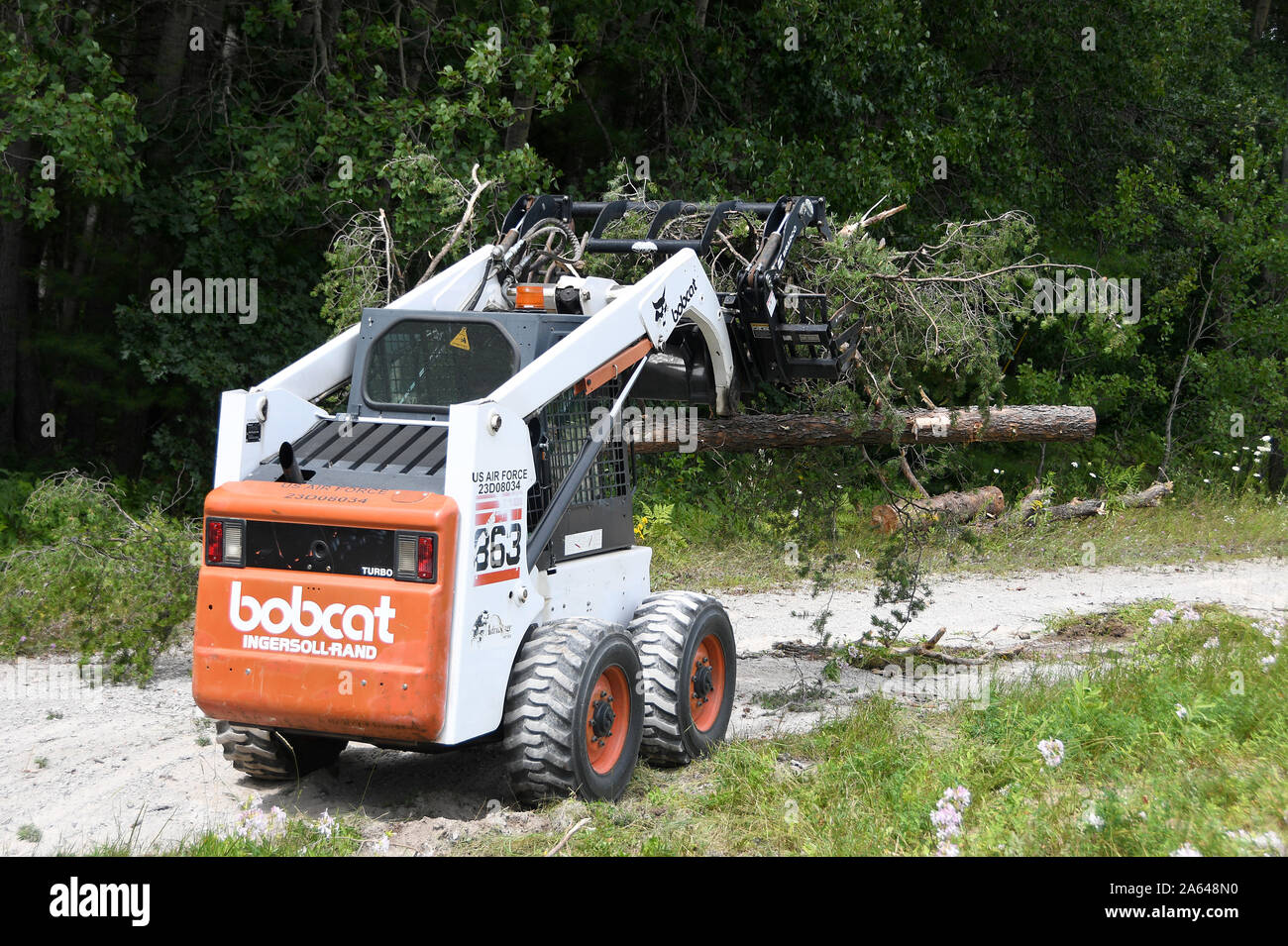 Col. Gregg Hesterman, the commander of the of the 178th Wing, operates a bobcat to practice clearing debris Aug. 13, 2019 at Alpena Combat Readiness Training Center in Alpena, Mich. Hesterman was able to learn from the 178th Civil Engineering Squadron Airmen on how they use their equipment to clear debris obstructions. (U.S. Air National Guard photo by Senior Airman Amber Mullen) Stock Photo