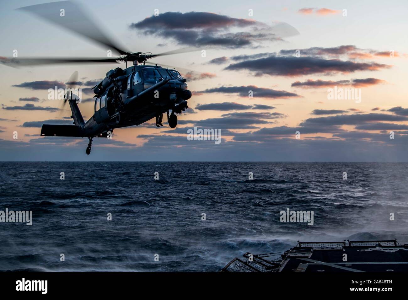 SEA OF JAPAN (Oct. 16, 2019) An HH-60 Pave Hawk helicopter, assigned to the U.S. Air Force’s 33rd Rescue Squadron, prepares to land on the flight deck of the Arleigh Burke-class guided-missile destroyer USS Milius (DDG 69) during joint deck landing qualifications. Milius is underway conducting operations in the Indo-Pacific region while assigned to Destroyer Squadron (DESRON) 15, the Navy’s largest forward-deployed DESRON and the U.S. 7th Fleet’s principal surface force. (U.S. Navy photo by Mass Communication Specialist 2nd Class Taylor DiMartino) Stock Photo