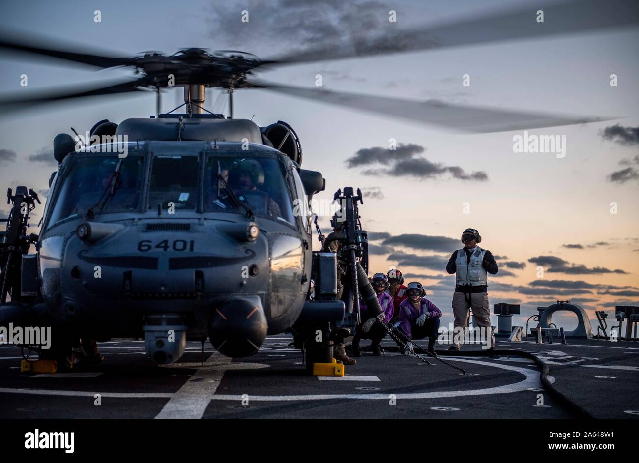 SEA OF JAPAN (Oct. 16, 2019) Sailors refuel an HH-60 Pave Hawk helicopter, assigned to the U.S. Air Force’s 33rd Rescue Squadron, on the flight deck of the Arleigh Burke-class guided-missile destroyer USS Milius (DDG 69) during joint deck landing qualifications. Milius is underway conducting operations in the Indo-Pacific region while assigned to Destroyer Squadron (DESRON) 15, the Navy’s largest forward-deployed DESRON and the U.S. 7th Fleet’s principal surface force. (U.S. Navy photo by Mass Communication Specialist 2nd Class Taylor DiMartino) Stock Photo