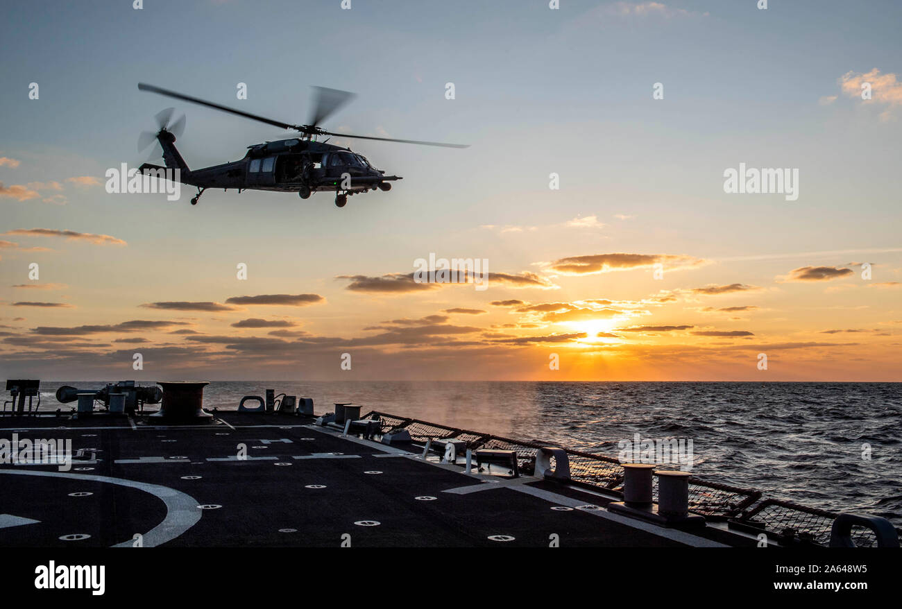 SEA OF JAPAN (Oct. 16, 2019) An HH-60 Pave Hawk helicopter, assigned to the U.S. Air Force’s 33rd Rescue Squadron, departs the flight deck of the Arleigh Burke-class guided-missile destroyer USS Milius (DDG 69) during joint deck landing qualifications. Milius is underway conducting operations in the Indo-Pacific region while assigned to Destroyer Squadron (DESRON) 15, the Navy’s largest forward-deployed DESRON and the U.S. 7th Fleet’s principal surface force. (U.S. Navy photo by Mass Communication Specialist 2nd Class Taylor DiMartino) Stock Photo