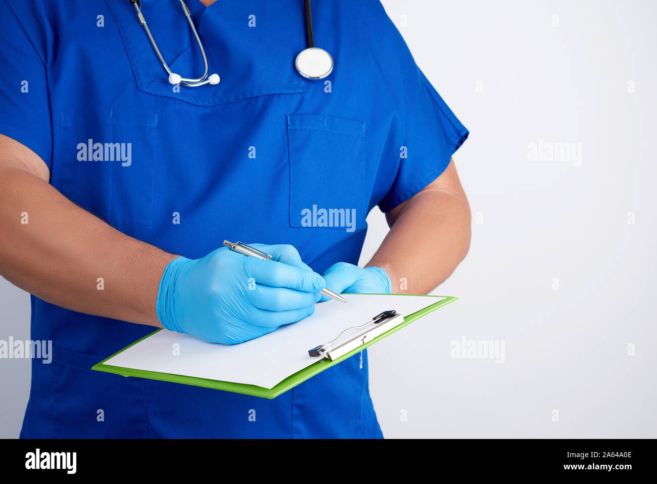 doctor in blue uniform and latex gloves holds a green holder for sheets ...