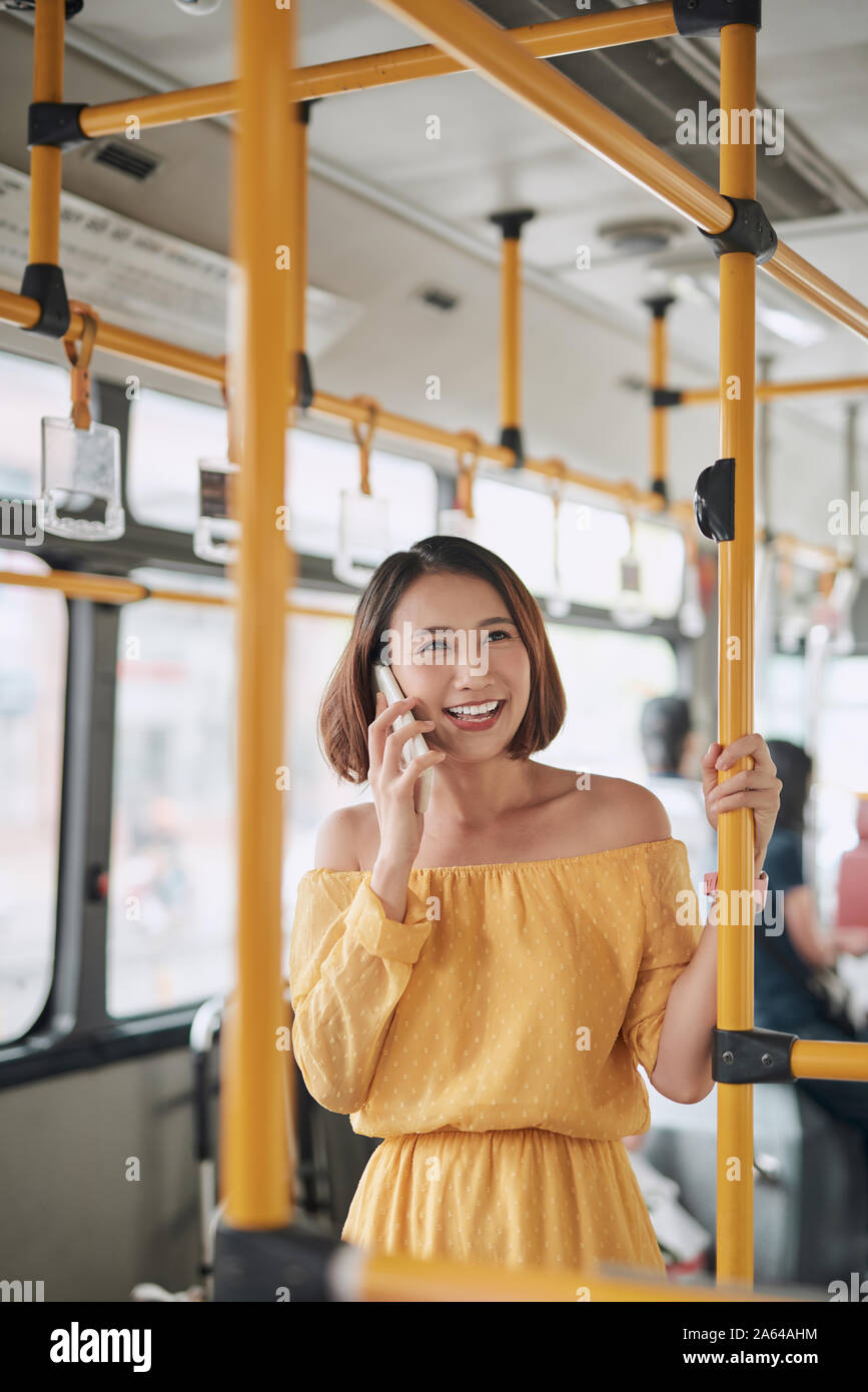Asian girl using phone on public bus Stock Photo