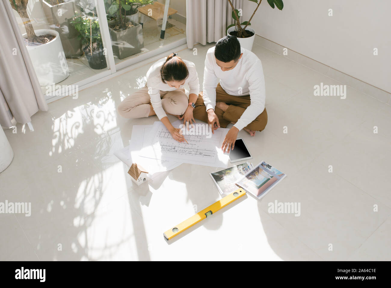 Young couple looking blueprints of they new house. Planning interior design Stock Photo