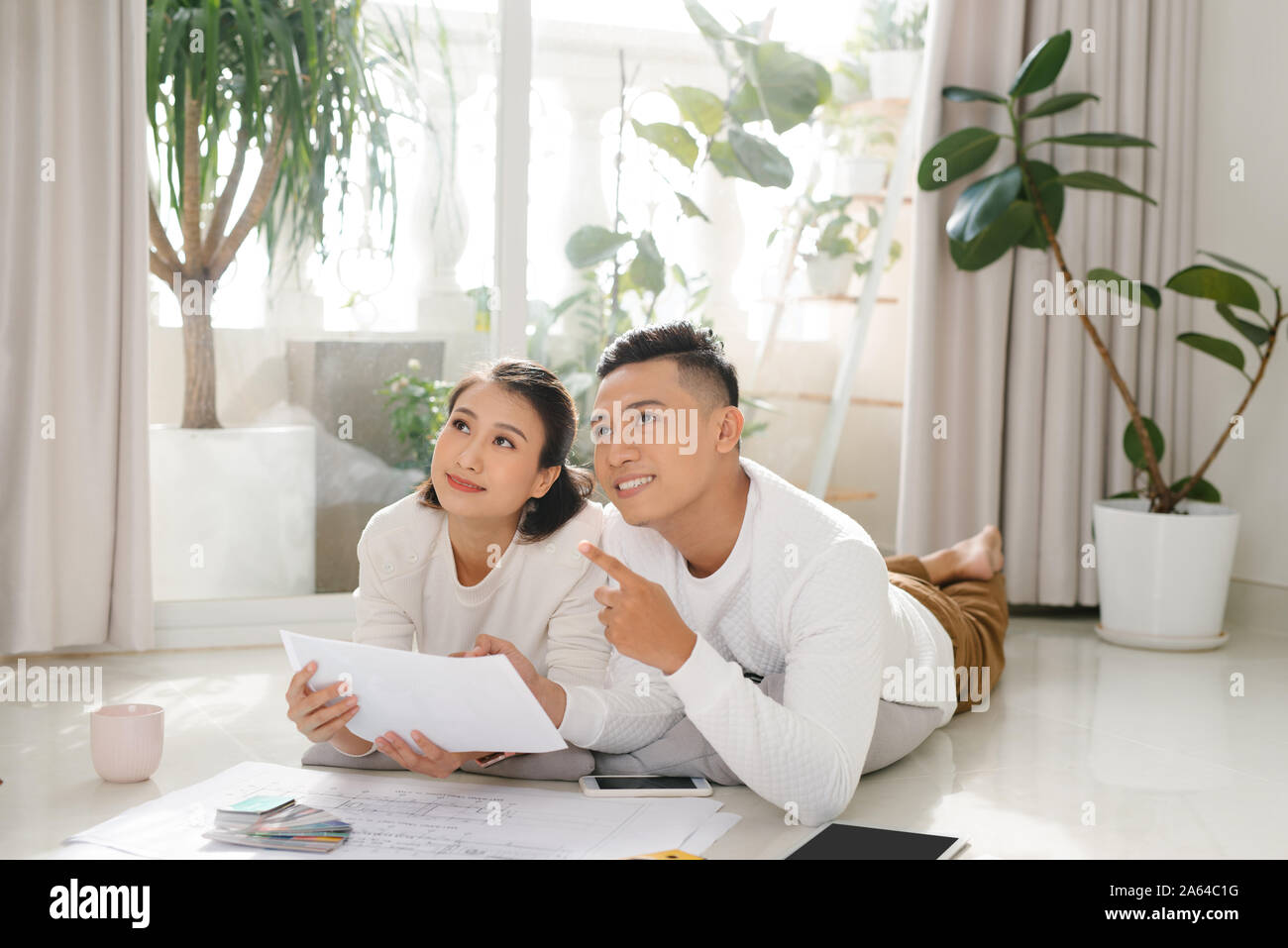 Homeowners talking about remodeling ideas, discussing house architectural plan moving in apartment Stock Photo
