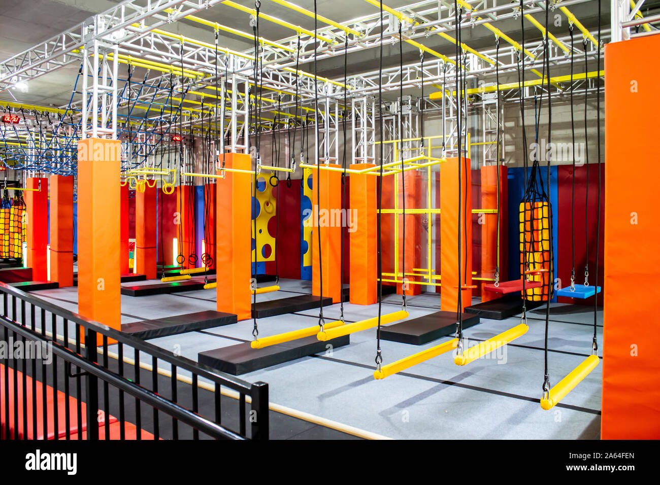 Brightly coloured interior ninja warrior parkour gym obstacle course with aerial netting Stock Photo