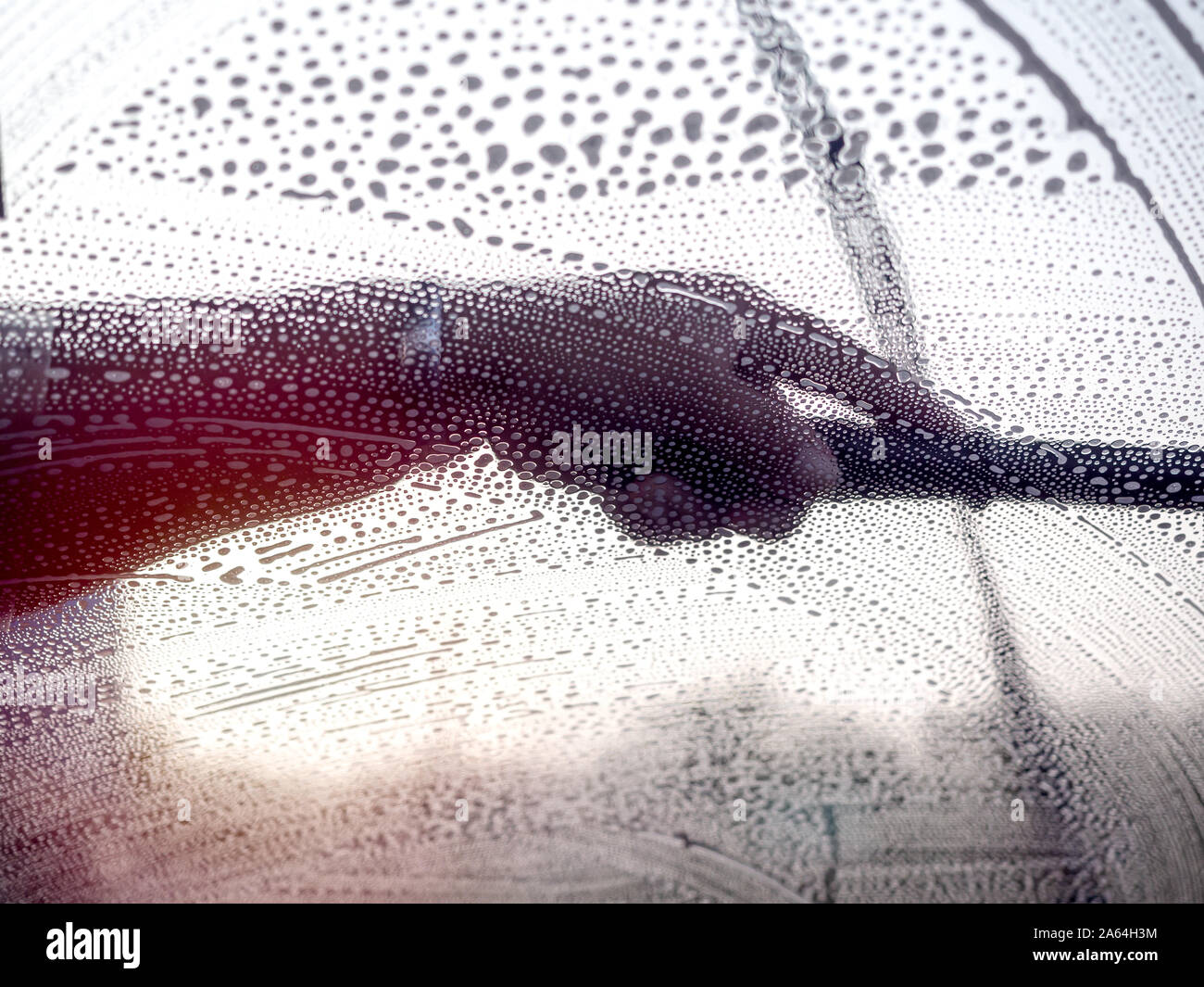 Windshield washing. Staff using squeegee cleaning the windshield, view