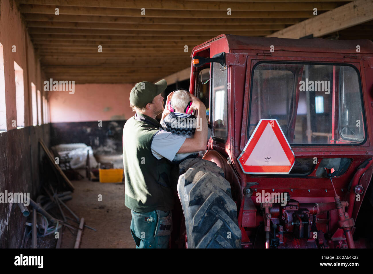Man holding baby girl on a tractor Stock Photo Alamy