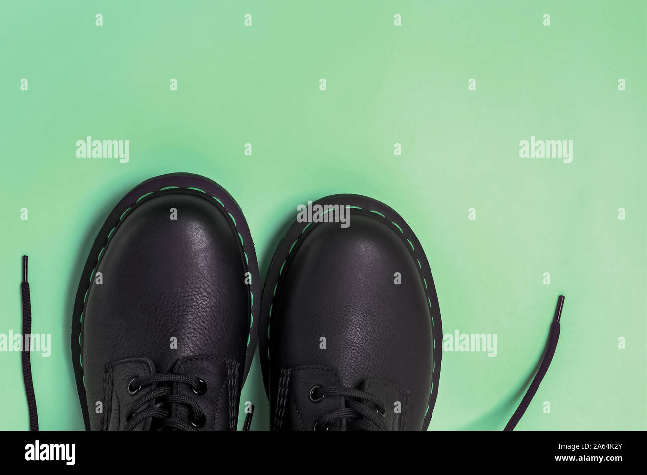 Classic leather boots isolated on pastel green background Stock Photo