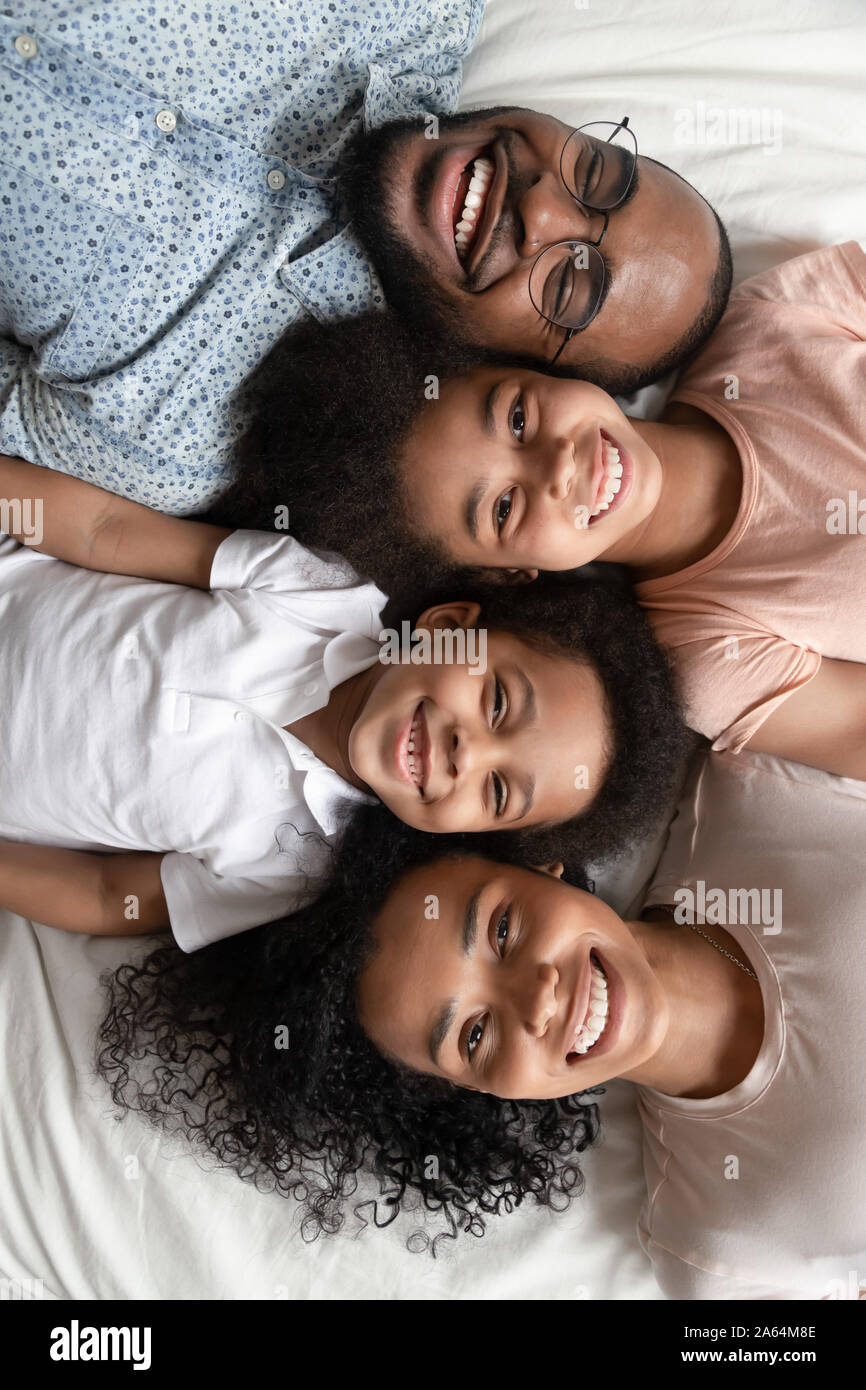 Top view portrait of smiling black family lying on bed Stock Photo - Alamy