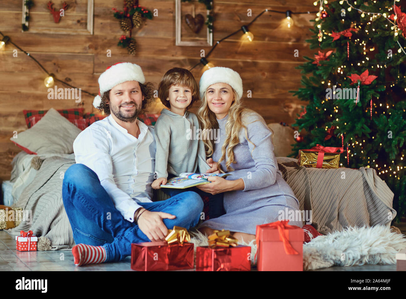 Family smiling in the house with a Christmas tree Stock Photo