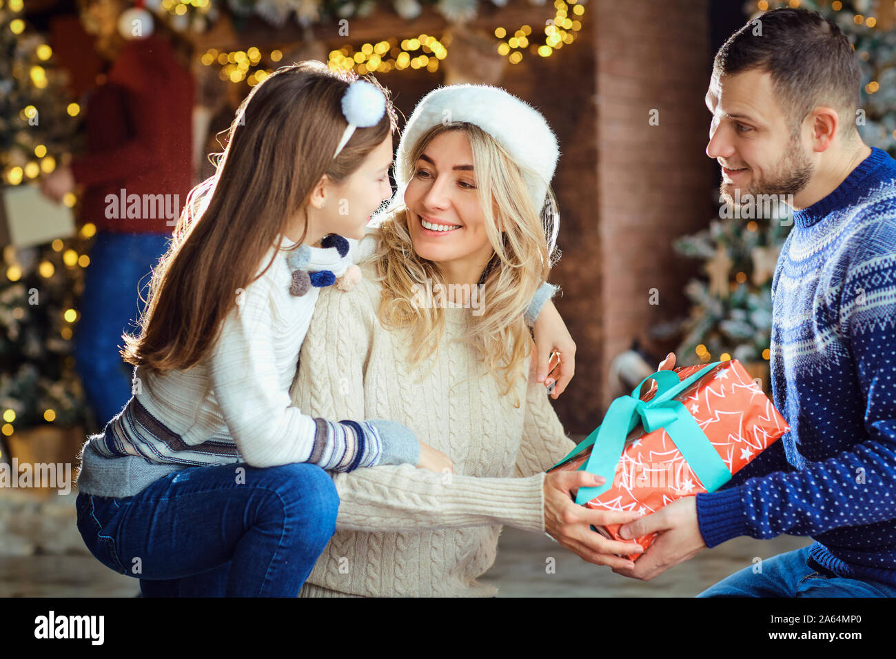 The family give gifts to the house at Christmas. Stock Photo